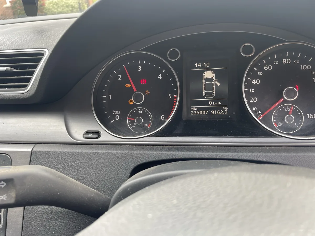 A VW Passat dashboard in Luton showing the engine warning light and the glow plug light both lit