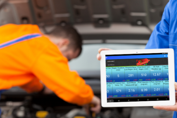 Mobile mechanic performing diagnostics and regeneration on a vehicle's DPF system for cleaning.